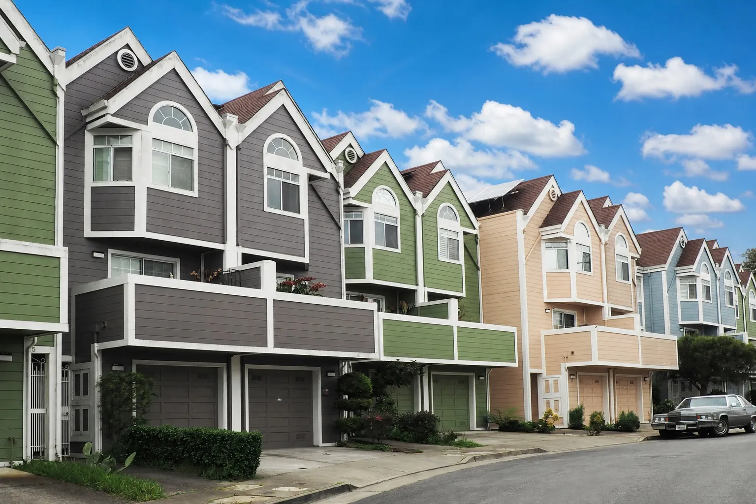 A row of colorful Colorado townhomes under a blue sky